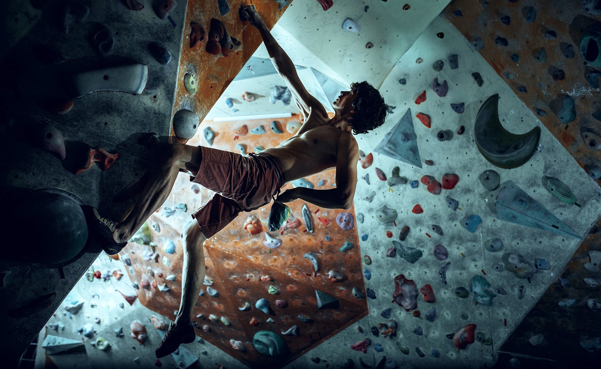 free climber young man climbing artificial boulder indoors min min